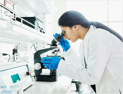 Female scientist using microscope while working in laboratory